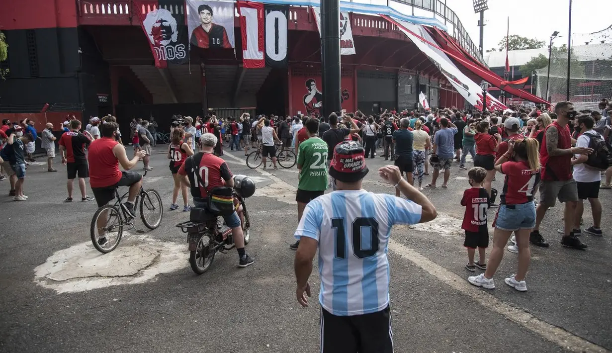 Fans tim sepak bola Newell's Old Boys Argentina, tempat legenda sepak bola Argentina Diego Maradona biasa bermain, berkumpul untuk meratapi kematiannya di luar Stadion Marcelo Bielsa, Rosario, Santa Fe, Argentina, 25 November 2020. (STR/AFP)