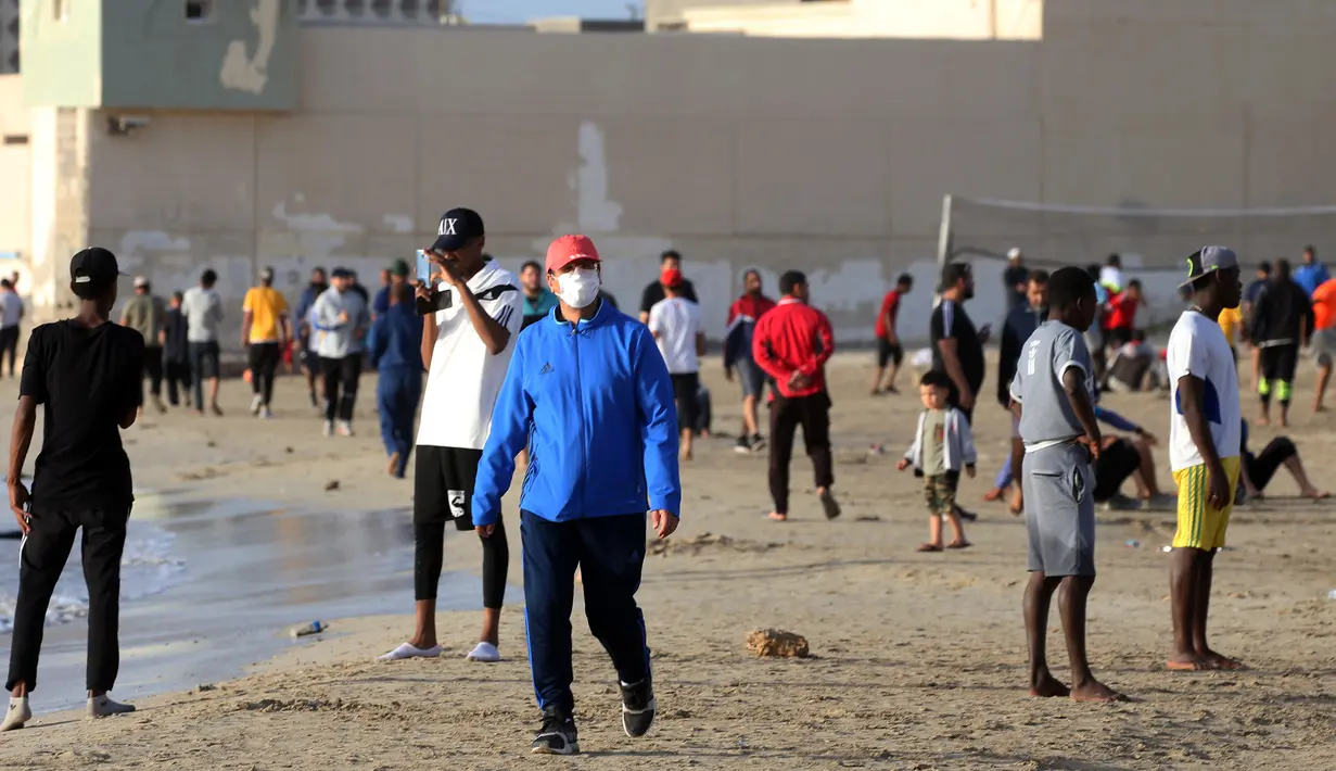 Orang-orang berolahraga di pantai sembari menunggu waktu berbuka puasa selama bulan suci Ramadan, meskipun lockdown karena pandemi COVID-19, di ibu kota Tripoli, Libya pada Jumat (8/5/2020). (Photo by Mahmud TURKIA / AFP)
