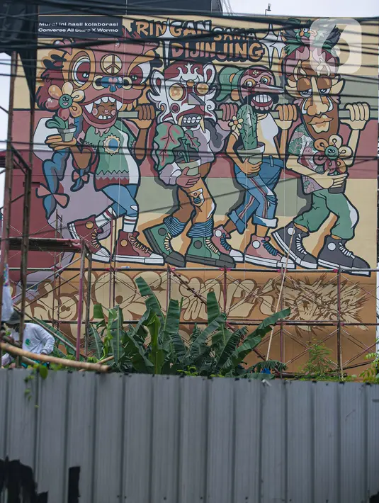 Seniman menyelesaikan pembuatan mural dalam acara Converse City Forest di Fatmawati, Jakarta, Sabtu (6/3/2021).  Mural digambar menggunakan cat khusus Grephenstone yang dapat menyerap polusi udara setara 177 pohon. (Liputan6.com/Faizal Fanani)