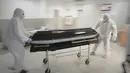 Karyawan rumah duka mengeluarkan peti mati korban COVID-19 dari kamar mayat Rumah Sakit Darurat Universitas di Bucharest, Rumania, Senin (8/11/2021). Selama beberapa minggu terakhir Rumania melaporkan rekor jumlah infeksi dan kematian baru setiap hari. (AP Photo/Vadim Ghirda)