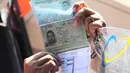 Petugas menunjukan paspor warga negara Iran saat rekonstruksi di Kantor Pos Pasar Baru, Jakarta, Selasa (1/7/14). (Liputan6.com/Faizal Fanani)