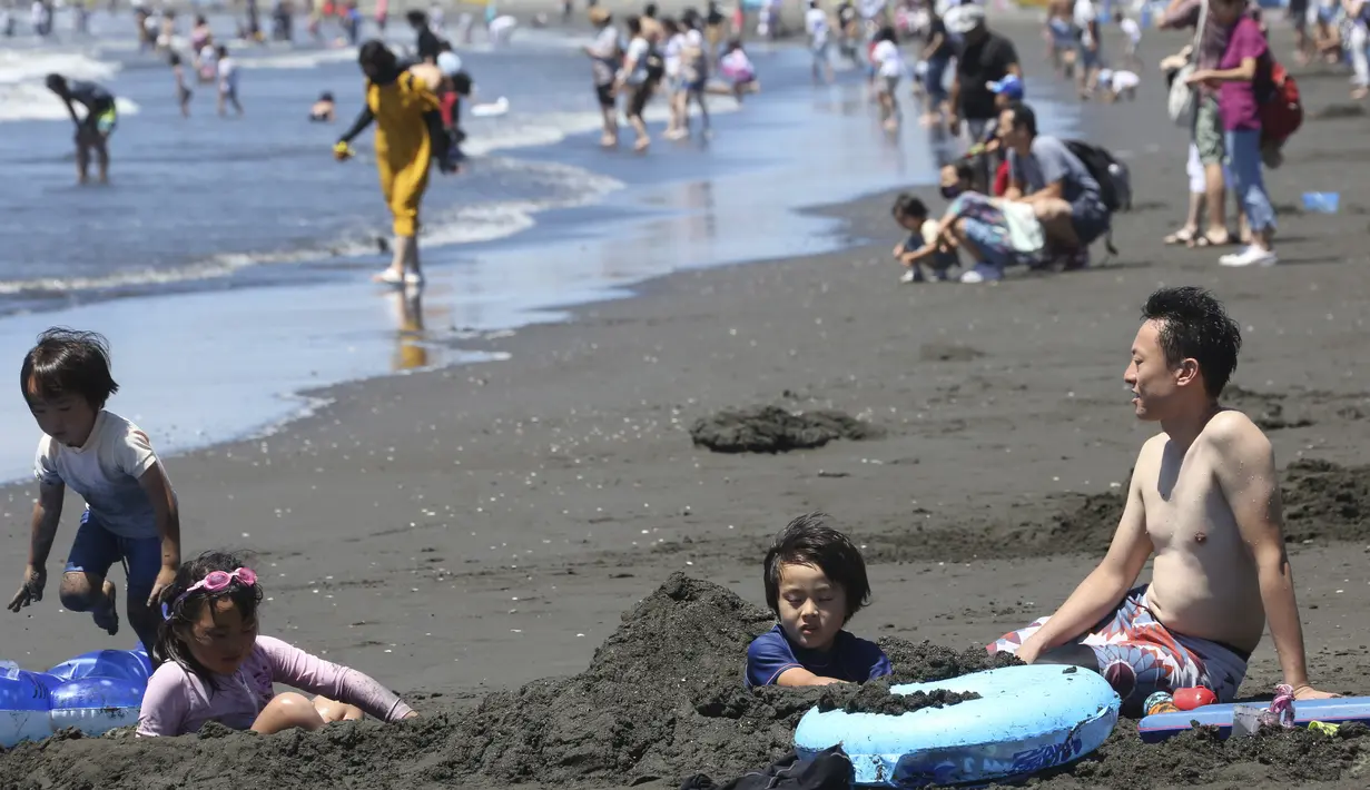 Orang-orang menikmati Pantai Shonan untuk menyejukkan diri dari teriknya musim panas di Fujisawa, dekat Tokyo, Selasa, (11/8/2020). (AP / Koji Sasahara)