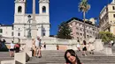 Beby Tsabina saat berpose Spanish Steps, Roma. Ia tampil cantik dengan busana serba pink sambil membawa tas serta sepatu warna putih. (Instagram/bebytsabin)
