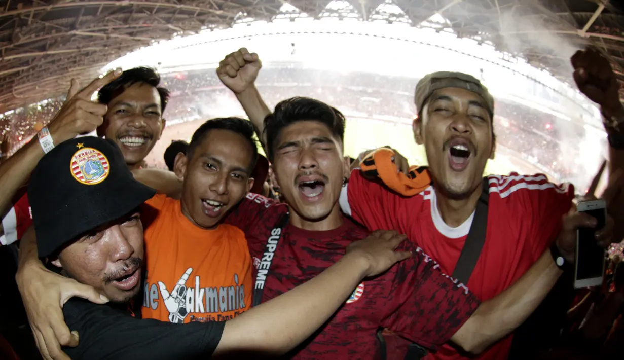 Suporter Persija Jakarta merayakan gelar juara Liga 1 di SUGBK, Jakarta, Minggu (09/12). Persija menang 2-1 atas Mitra Kukar. (Bola.com/M Iqbal Ichsan)