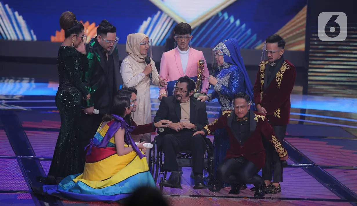 Penyanyi dangdut senior Hamdan ATT mendapatkan penghargaan Lifetime Achievement dalam acara Indonesian Dangdut Awards 2021 di Studio 5 Indosiar, Jakarta, Rabu (1/12/2021). Penghargaan diberikan atas dedikasi Hamdan ATT untuk musik dangdut di tanah air. (Liputan6.com/Faizal Fanani)