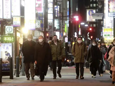 Orang-orang memakai masker untuk melindungi dari penyebaran virus corona berjalan di sepanjang jalan yang dipenuhi bar dan restoran di Tokyo, Rabu (19/1/2022). Tokyo dan puluhan daerah lain di Jepang akan menghadapi pembatasan COVID-19 baru yang berlaku efektif Jumat (21/1). (AP Photo/Koji Sasahara)