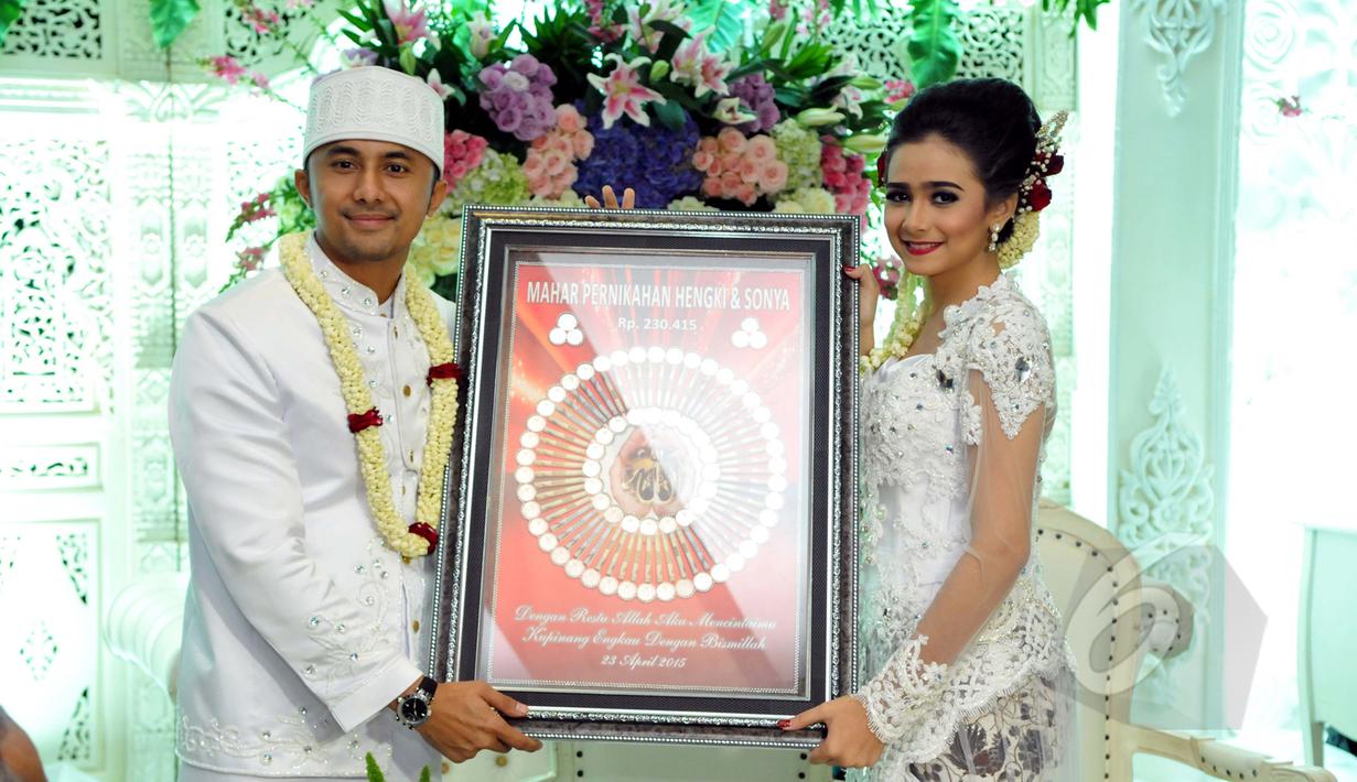 Hengky Kurniawan dan Sonya Fatmala memperlihatkan mahar pernikahan mereka seusai prosesi akad nikah di sebuah hotel kawasan TMII, Jakarta, Kamis (23/4/2015). (Liputan6.com/Panji Diksana)