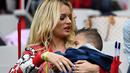 Ludivine Payet menggendong anaknya saat menonton suaminya Dimitri Payet bersama tim Prancis melawan Islandia pada perempat final Piala Eropa 2016 di Stade de France, Saint-Denis, Paris. (4/7/2016) dini hari WIB. (AFP/Franck Fife)