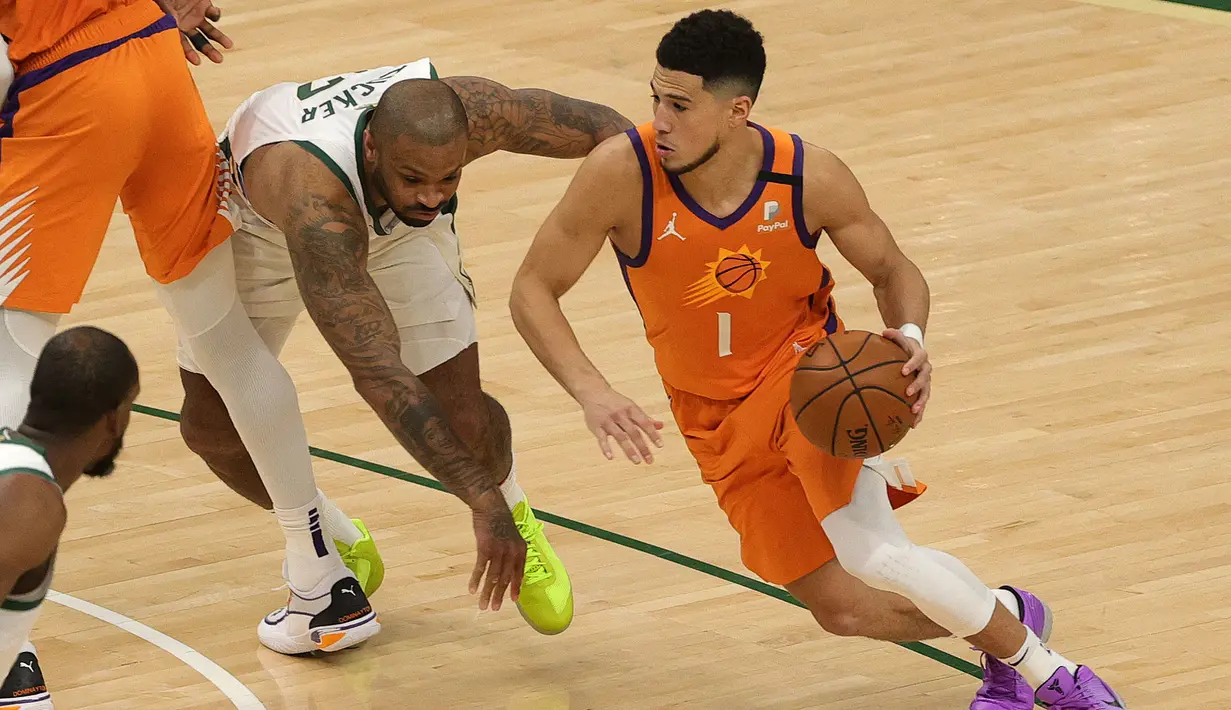 Walaupun tampil di hadapan pendukungnya, Bucks harus kesulitan membendung serangan Suns di awal pertandingan. Devin Booker (kanan) berhasil tampil gemilang dan bawa Suns unggul 23-20 di kuarter pertama. (Foto: Getty Images via AFP/Stacy Revere)