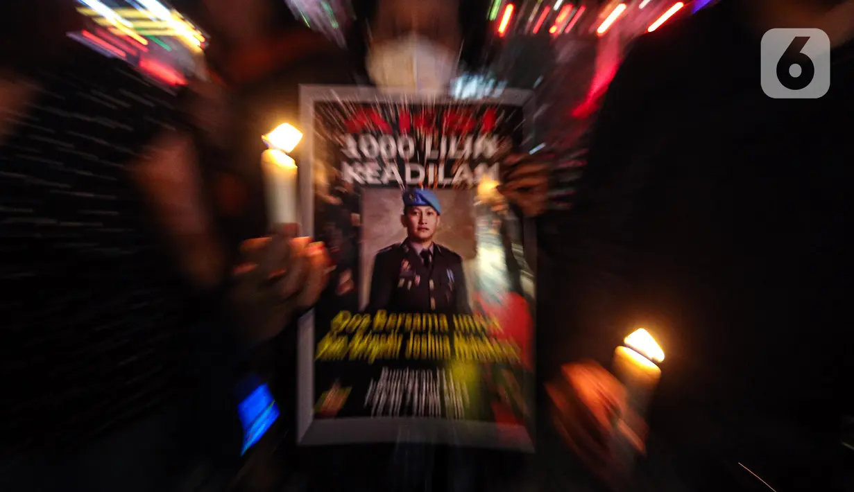 Massa aksi yang tergabung dalam Tim Advokat Penegak Hukum dan Keadilan (Tampak) menunjukkan poster bergambar Brigadir Yosua Hutabarat atau Brigadir J saat aksi 1000 lilin atas kematiannya di Bundaran HI, Jakarta, Jumat (22/7/2022). Aksi tersebut sebagai bentuk keadilan terkait kematian Brigadir J yang diduga akibat penyiksaan. (Liputan6.com/Faizal Fanani)