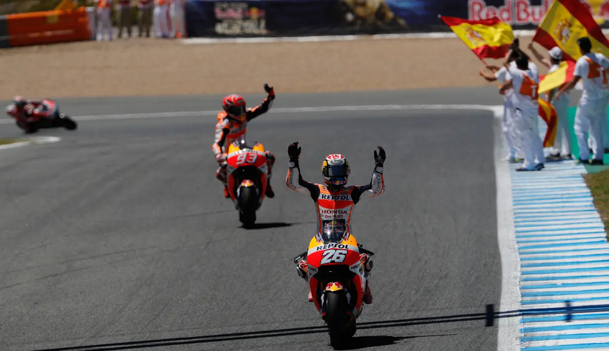 Pembalap Repsol Honda, Dani Pedrosa (kanan) melakukan selebrasi di atas motornya setelah berhasil finis pertama pada balapan MotoGP Spanyol di Sirkuit Jerez, Minggu (7/5). Ini kemenangan perdana Pedrosa pada tahun ini. (AP Photo/Miguel Morenatti)