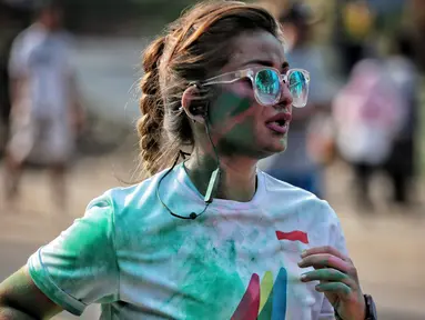 Seorang wanita saat mengikuti lari santai The Color Run di kawasan komplek Gelora Bung Karno, Jakarta, Minggu (16/9). Sebanyak 13.000 peserta mengikuti The Color Run. (Liputan6.com/Faizal Fanani)