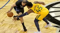Pemain Utah Jazz Donovan Mitchell berebut bola dengan pemain Magic di lanjutan NBA (AP)