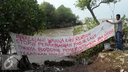 Nelayan memasang spanduk berisi penolakan penambangan pasir laut di perairan Serang, Banten, Rabu (27/4). (Liputan6.com/Helmi Afandi)