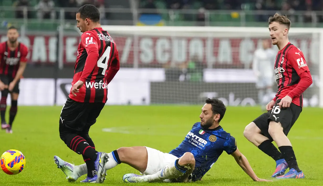 Pemain Inter Milan Hakan Calhanoglu berebut bola dengan pemain AC Milan Ismael Bennacer (kiri) dan Alexis Saelemaekers pada pertandingan leg pertama semifinal Coppa Italia di Stadion San Siro, Milan, Italia, 1 Maret 2022. Pertandingan berakhir imbang 0-0. (AP Photo/Antonio Calanni)