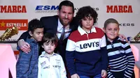 Megabintang Barcelona, Lionel Messi berpose dengan anak-anak dari rumah sakit de Joan de Deu setelah menerima trofi Sepatu Emas Eropa kelimanya dalam sebuah acara di Antiga Fabrica Estrella Damm, Selasa (18/12). (LLUIS GENE/AFP)