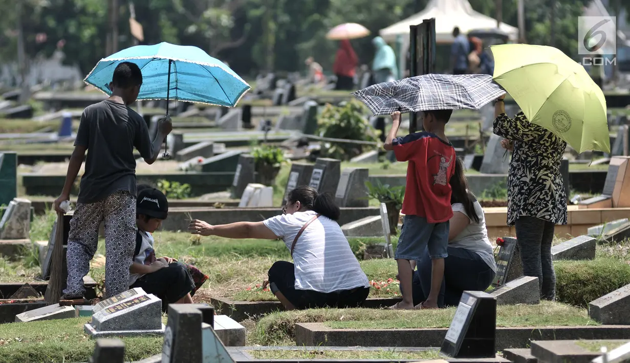 Kelompok anak-anak menawarkan jasa membersihkan makam di TPU Penggilingan, Pulogadung, Jakarta, Kamis (10/5). Tradisi ziarah jelang Ramadan menjadi berkah bagi anak-anak pembersih makam atau biasa dikenal 'Ngoret'. (Merdeka.com/Iqbal S. Nugroho)