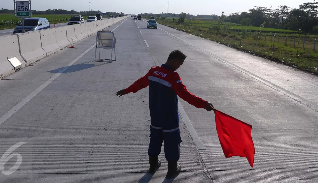 Petugas berjaga di lokasi saat pemberlakuan contra flow di dalam Tol Brebes, Jawa Tengah, Senin (4/7). Contra flow tersebut diberlakukan untuk memecah kemacetan di Tol Pejagan. (Liputan6.com/Angga Yuniar)