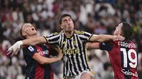 Striker Juventus, Dusan Vlahovic (tengah) dikepung dua pemain Bologna pada pertandingan Serie A 2023/2024 di Allianz Stadium, Turin, Senin (28/8/2023) dini hari WIB. (Marco Alpozzi/LaPresse via AP)