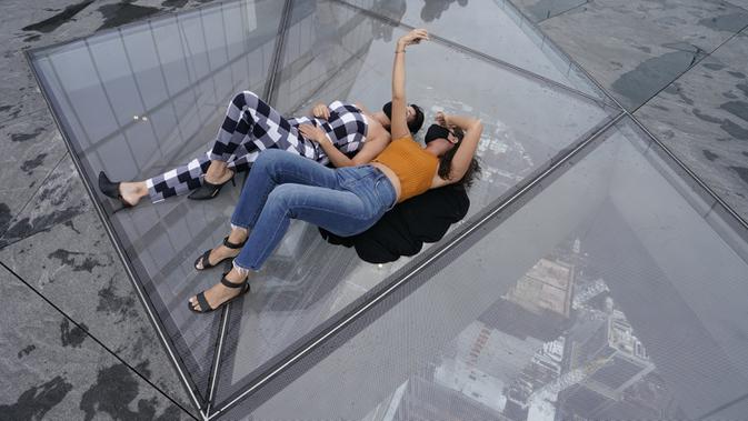 Pengunjung berswafoto dari Edge, dek langit tertinggi di luar ruangan di Western Hemisphere saat dibuka kembali untuk umum di New York, Rabu (2/9/2020). Dek yang berada di lantai 100 menara utama Hudson Yards itu memiliki tinggi 1.100 kaki atau setara 335 meter (TIMOTHY A. CLARY/AFP)