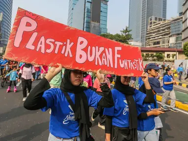 Sejumlah pegiat lingkungan membawa poster saat pawai bebas plastik di Kawasan Sudirman, Jakarta, Minggu (30/7/2023). (Liputan6.com/Faizal Fanani)