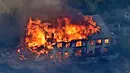Sebuah rumah terbakar saat kebakaran melanda Calabasas, Los Angeles, California, AS, Jumat (9/11). Pemerintah setempat mendeklarasikan udara tak sehat serta memerintahkan warga untuk tak bepergian. (AP Photo/Mark J. Terrill)