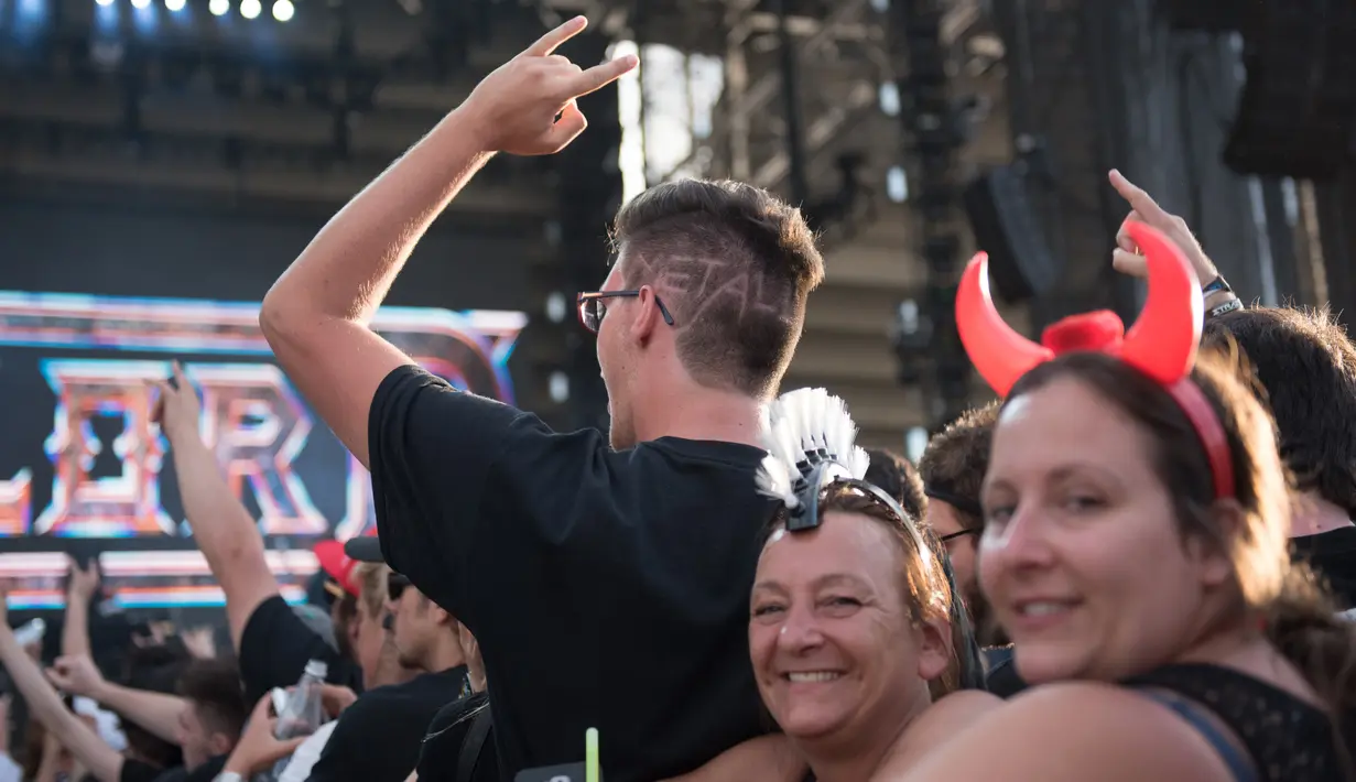 Sejumlah penonton menyaksikan aksi panggung Metallica saat tampil di Festival d'ete de Quebec di Quebec City, Kanada (14/7). Ribuan penonton terhibur dengan aksi panggung band metal tersebut. (AFP Photo/Alice Chicheby)