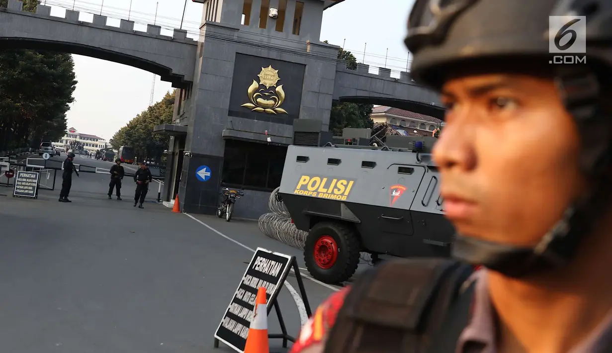 Aparat keamanan berjaga di depan pintu gerbang Mako Brimob Kelapa Dua, Depok, Jawa Barat, Rabu (9/5). Kerusuhan napi teroris yang terjadi di Mako Brimob menyebabkan penjagaan di kawasan tersebut terus diperketat. (Liputan6.com/Immanuel Antonius)