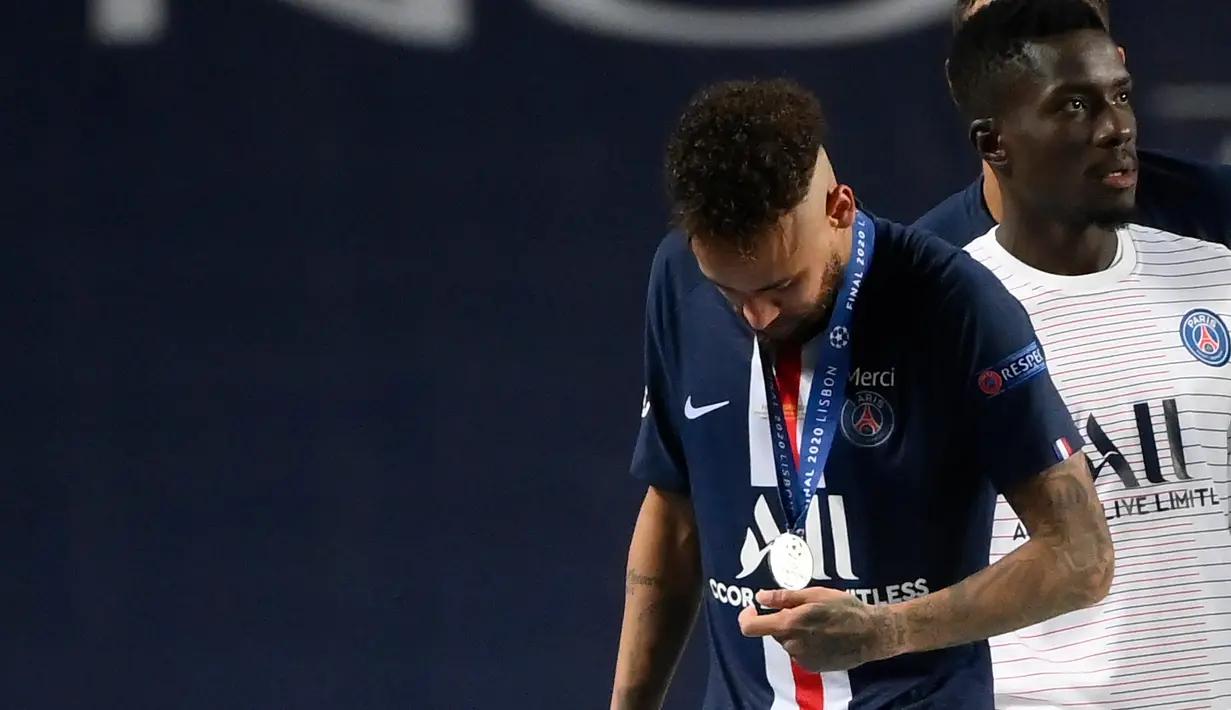 Penyerang PSG, Neymar melihat medalinya setelah pertandingan final Liga Champions melawan ayern Munchen di stadion Luz di Lisbon, Portugal, Minggu, (23/8/2020). Bayern Munchen menang tipis atas PSG 1-0. (AFP/Lluis Gene)