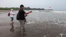 Keluarga menaburkan bunga ke laut dalam prosesi untuk lima jurnalis dan tiga kru kapal Arupadhatu 1 di pantai dekat Dermaga Pegedongan, Banten, Jumat (18/9/2026). Dermaga tersebut menjadi titik awal keberangkatan delapan orang itu pada Senin (7/9/2026). (KLY/Budy Santoso)