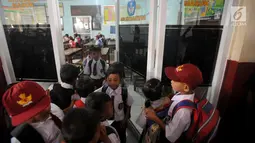 Siswa kelas 1 menunggu giliran untuk belajar di ruang guru SD Negeri Kotabatu 08 Kecamatan Ciomas Kabupaten Bogor, Senin (23/7). Hal itu terpaksa dilakukan akibat ambruknya dua bangunan kelas di lingkungan SDN Kota Batu. (Merdeka.com/Arie Basuki)