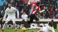 Pemain Athletic Bilbao, Iker Muniain (tengah) menerima tackle dari pemain Real Madrid, Luka Modric pada lanjtan La Liga Spanyol pekan ke-24 di Stadion Santiago Bernabeu,  Madrid, Sabtu (13/2/2016).  (AFP / Curto De La Torre)