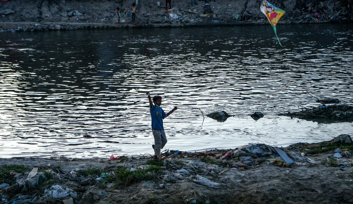 Seorang anak menerbangkan layang-layang di tepi sungai menjelang festival Hindu Dashain di Kathmandu (7/10/2020). Festival ini jatuh pada bulan September atau Oktober, dimulai dari shukla paksha (dua minggu bulan cerah) di bulan Ashwin dan berakhir pada Purnima, bulan purnama. (AFP/Prakash Mathema)