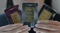 Seorang karyawan menunjukkan emas batangan 25, 50, dan 100 gram produksi Galeri 24, anak perusahaan dari PT Pegadaian (Persero), di Jakarta pada 14 April 2025. (BAY ISMOYO/AFP)
