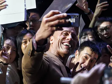 Aktor Dwayne Johnson berswafoto bersama penggemar selama acara red carpet dalam premiere film 'Fast & Furious: Hobbs & Shaw' di Beijing, China, Senin (5/8/2019). Hobbs and Shaw menempatkan dua aktor laga papan atas, Jason Statham dan Dwayne Johnson sebagai pemeran utama. (AP Photo/Andy Wong)