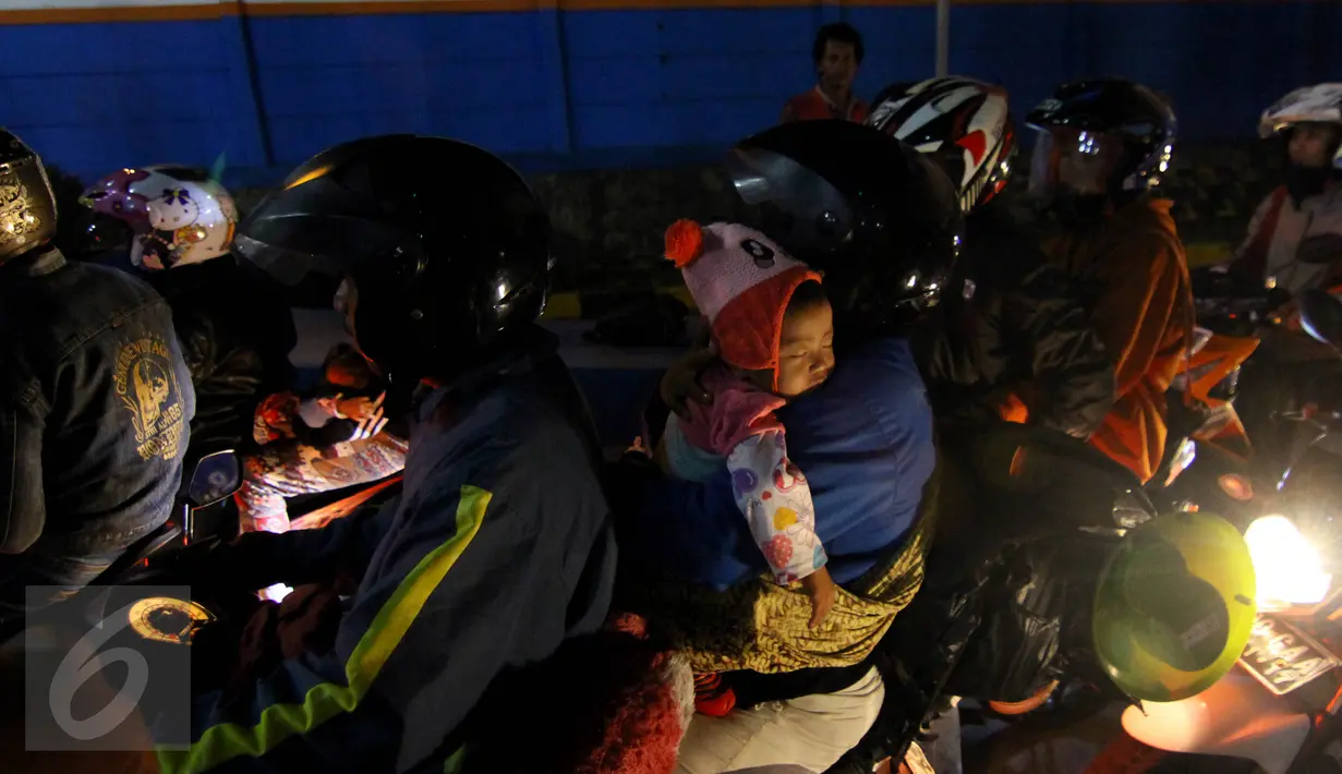 Pemudik bersepeda motor yang membawa anak kecil terlihat mengantre panjang di Pelabuhan Merak, Banten, Rabu dinihari (15/7/2015). KPAI meminta pemudik yang menggunakan sepeda motor tidak membawa anak karena sangat membahayakan. (Liputan6.com/Johan Tallo)