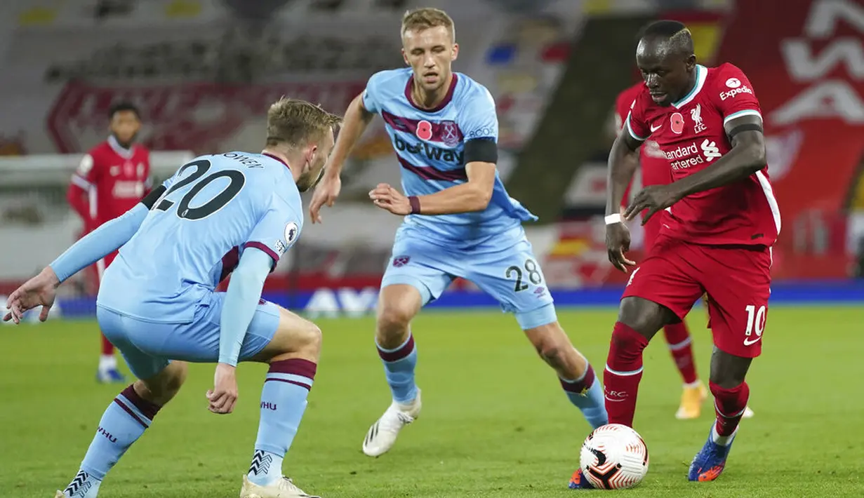 Penyerang Liverpool, Sadio Mane, berusaha melewati pemain West Ham United pada laga Liga Inggris di Stadion Anfield,  Minggu (1/11/2020). Liverpool menang dengan skor 2-1. (AP Photo/Jon Super, Pool)