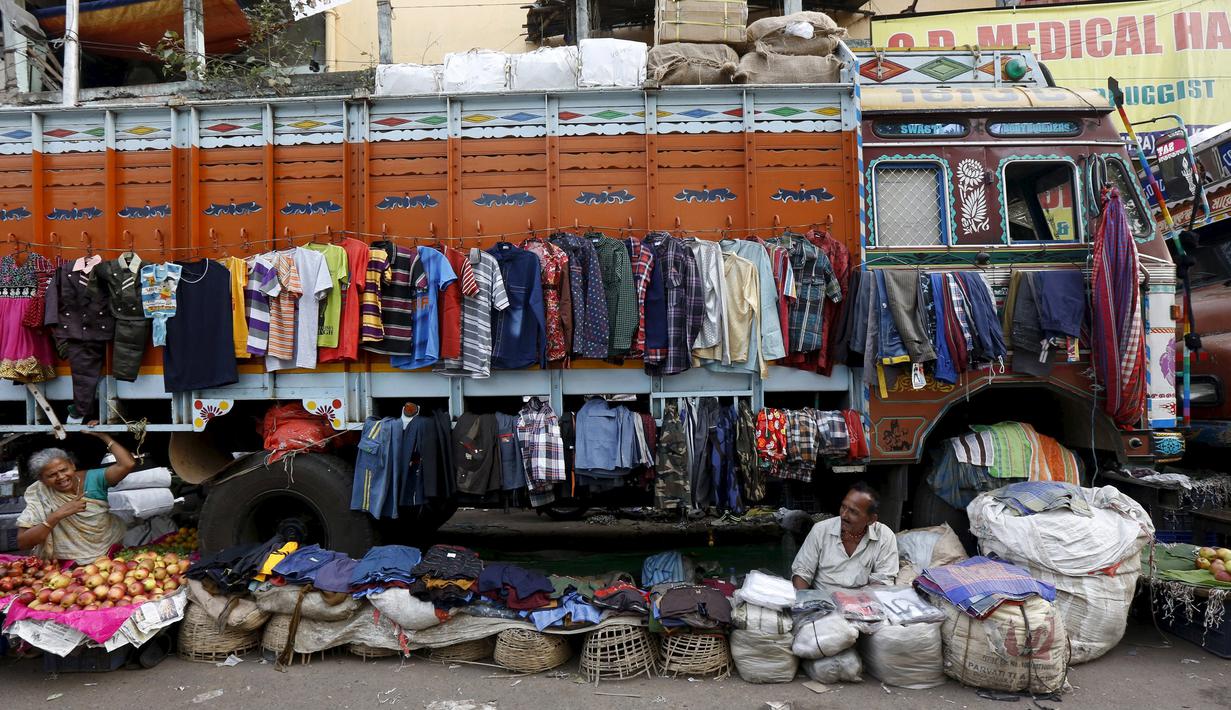 Sabitri Das dan Narayan Prasad menjajakan dagangan mereka di depan sebuah truk di daerah kumuh Kolkata, India, 11 Maret 2016. Kota ini memiliki kekurangan perumahan yang parah, setidaknya 1 juta orang tidur di jalan. (REUTERS/Rupak De Chowdhuri)