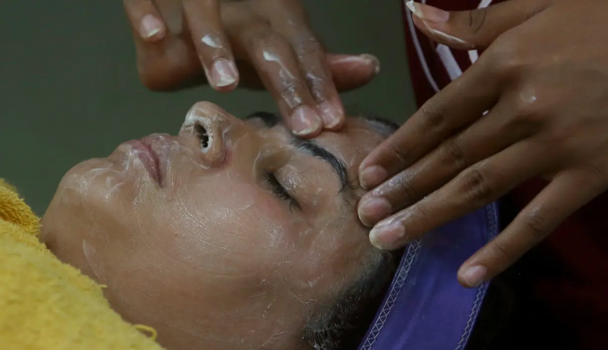 Seorang wanita Pakistan saat dibersihkan wajanya untuk persiapan Hari Raya Idul Fitri di Karachi (3/6/2019). Umat Muslim di seluruh dunia sedang bersiap untuk merayakan Hari Raya Idul Fitri, yang menandai akhir bulan puasa Ramadan. (AP Photo/Fareed Khan)