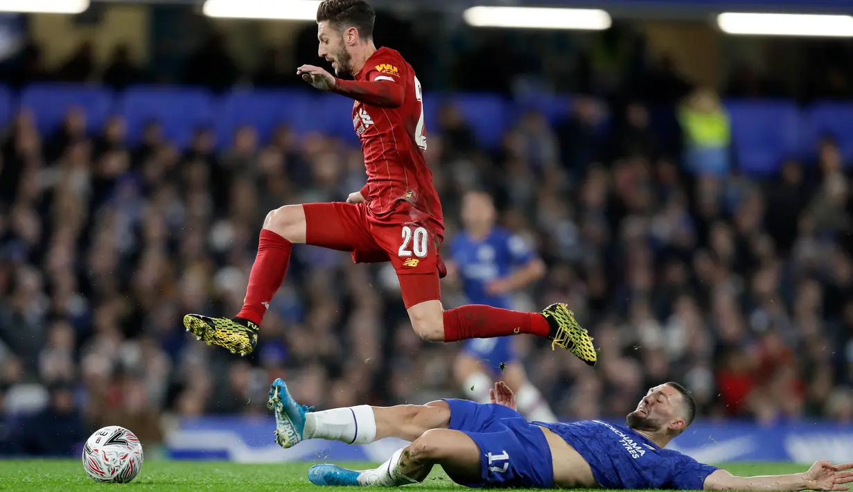 Gelandang Liverpool Adam Lallana melompat saat merebut bola dari pemain Chelsea, Mateo Kovacic pada laga putaran lima Piala FA di Stamford Bridge, London, Selasa (3/3/2020). Chelsea mengemas kemenangan telak 2-0 atas tamunya Liverpool. (AP/Kirsty Wigglesworth)