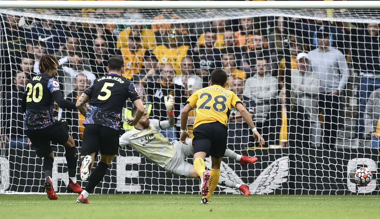 Dele Alli (kiri) menjadi keran gol Tottenham lewat tendangan pinalti setelah dirinya dijatuhkan di kotak dua belas pas. Ia sukses melesatkan bola ke sudut kiri dari arah kiper Wolves, Jose Sa. Papan skor berubah menjadi 1-0 dengan keunggulan The Lilywhites. (Foto: AP/Rui Vieira)
