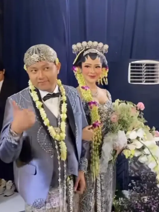 Kali ini, keduanya mengenakan pakaian pengantin berwarna abu-abu. Bella mengenakan kebaya berhias payet perak berkilauan. Kebaya modell off shoulder tersebut dipadukan dengan selendang organza warna senada.