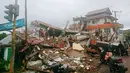Warga memeriksa bangunan yang rusak akibat gempa di Mamuju, Sulawesi Barat, Indonesia, Jumat (15/1/2021). Sejumlah rumah dan bangunan di Mamuju roboh akibat gempa dengan berkekuatan 6,2 skala Richter yang berpusat di timur laut Majene. (AP Photo/Rudy Akdyaksyah)