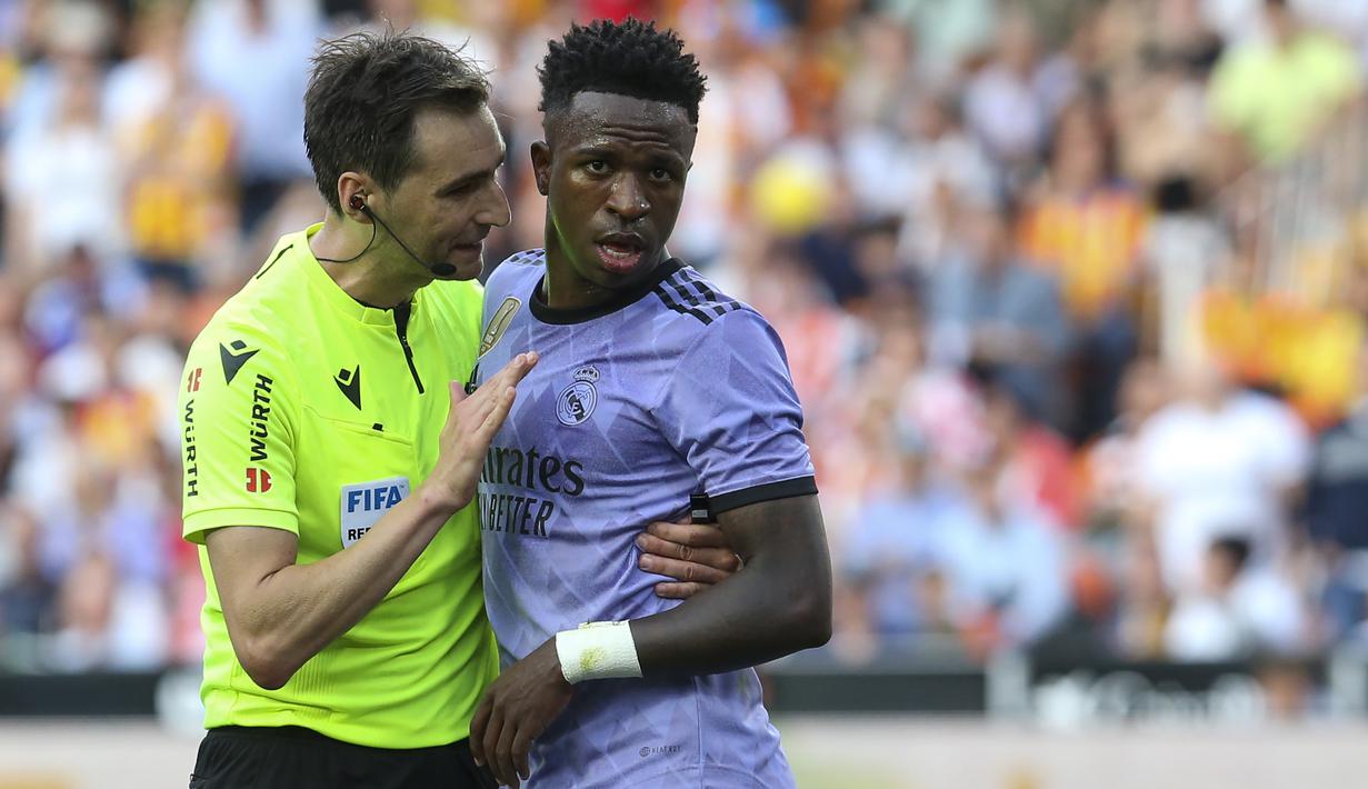 Wasit Ricardo De Burgos Bengoetxea berusaha menenangkan striker Real Madrid, Vinicius Junior pada laga pekan ke-35 Liga Spanyol 2022/2023 di Mestalla Stadium, Valencia, Senin (22/5/2023) dini hari WIB. (AP Photo/Alberto Saiz)
