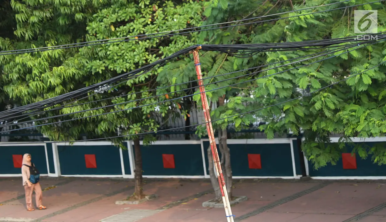 Kondisi instalasi kabel yang di sangga oleh tiang bambu di kawasan Pasar Baru, Jakarta, Selasa (12/9). Selain membahayakan pengguna jalan, buruknya instalasi kabel tersebut juga merusak estetika kota. (Liputan6.com/Immanuel Antonius)