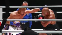 Roy Jones Jr melakukan pukulan terhadap Mike Tyson pada pertarungan tinju eksibisi di Los Angeles, Amerika Serikat, Sabtu (28/11/2020). Pertandingan berakhir tanpa pemenang alias imbang. (Joe Scarnici/Triller via AP)