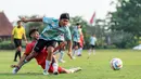 Seorang pemain Timnas Indonesia U-16 berusaha melewati adangan pemain SSB Terang Bangsa pada laga uji coba di Lapangan Yogyakarta International School (YIS), Jumat (31/5/2024). (Bola.com/Radifa Arsa)