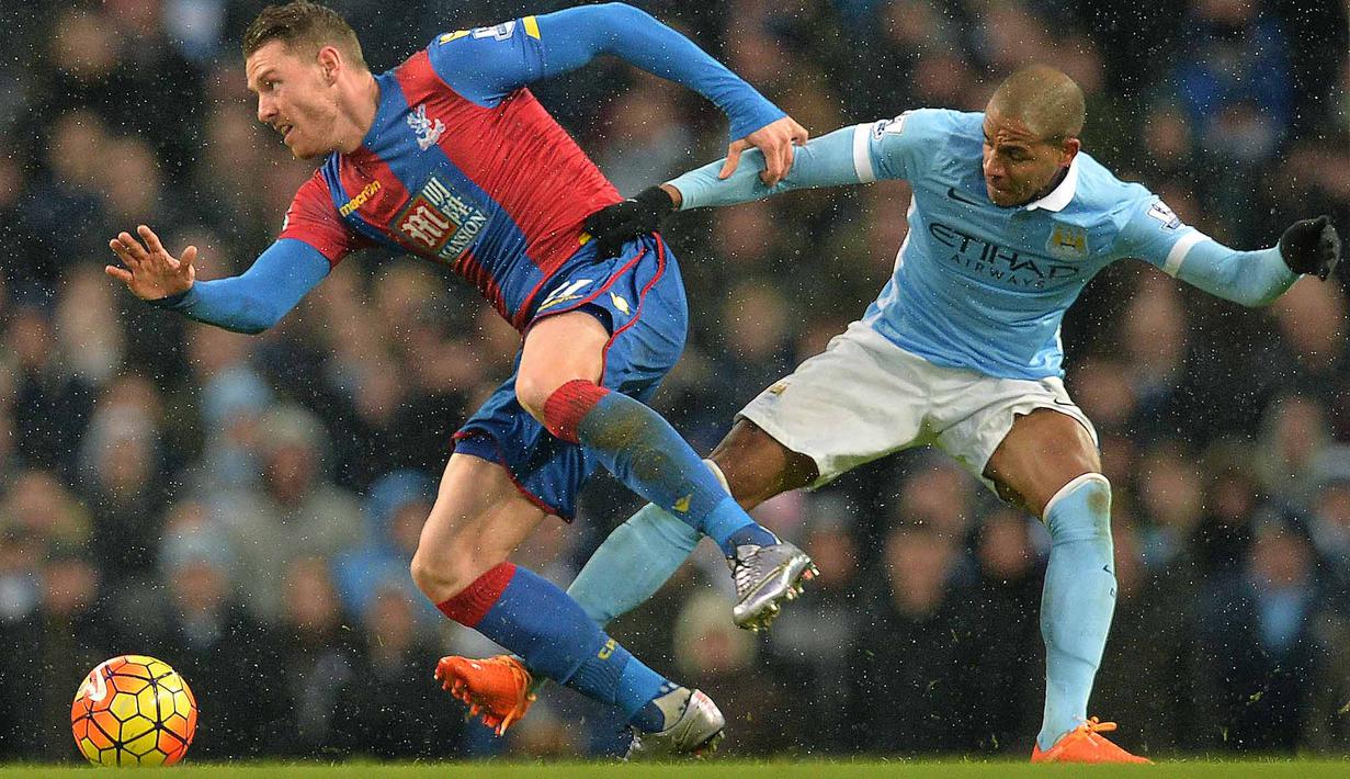 Pemain Crystal Palace, Connor Wickham (kiri) berusaha melewati pemain Manchester City pada lanjutan liga premier Inggris di Stadion Etihad, Manchester, Sabtu (16/1/2016). (AFP Photo/Paul Ellis)