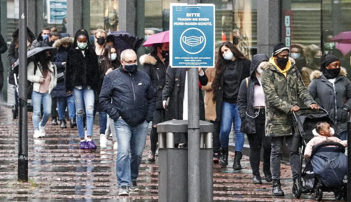 Orang-orang mengantre di depan sebuah toko di pusat Kota Essen, Jerman, Senin (14/12/2020). Jerman melakukan lockdown nasional pada 16 Desember 2020 untuk memerangi pandemi COVID-19. (AP Photo/Martin Meissner)
