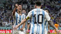 Pemain Argentina, Nahuel Molina (kiri) merayakan gol pertama timnya yang berasal dari assist Lionel Messi saat perempat final Piala Dunia 2022 melawan Belanda yang berlangsung di Stadion Lusail, Jumat (09/12/2022) waktu setempat. Laga yang awalnya imbang 2-2 hingga extratime 2x15 menit, dimenangkan oleh Argentina pada babak adu penalti dengan skor 4-3. (AP/Ricardo Mazalan)